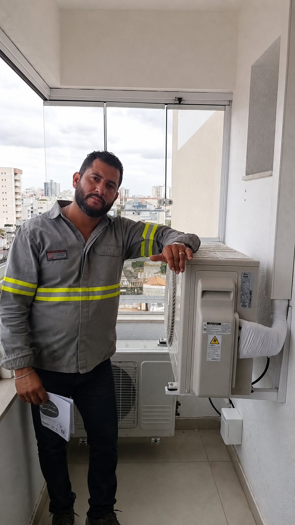 Técnico da PH Climatização ao lado de condensadora de ar-condicionado instalada em varanda residencial